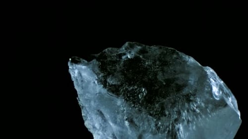 Translucent Ice Block Shifting on Black Background