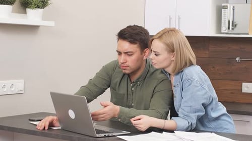 Couple Using Laptop Together in Modern Home Kitchen