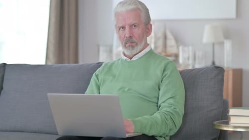 Senior Man Using Laptop Sitting on Couch