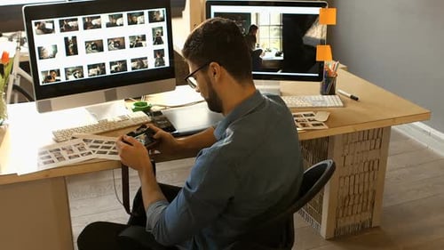 Young Adult Working at Computer with Camera