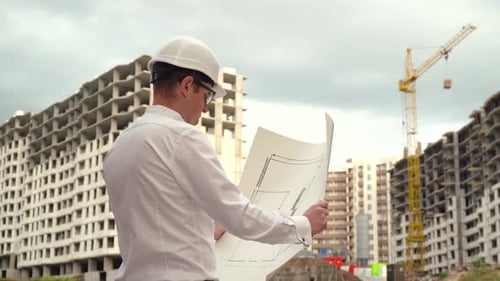 Engineer Examining Construction Plan at Building Site