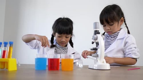 Young Girls Conducting a Science Experiment in Lab