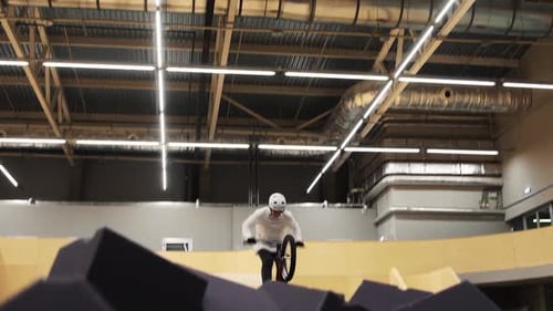 BMX Sports Young Man Doing a Flip on His Bike Then Falls in the Pool Filled with Sponges