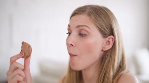 Fair-Haired Woman Eating Chocolate Macaron