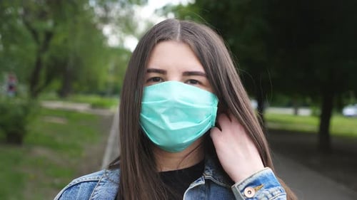 Happy Woman Removing Face Mask in Urban Park