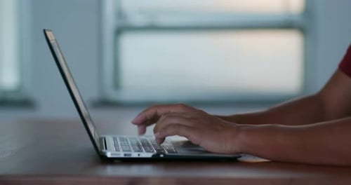 Hands Typing on Laptop Keyboard Indoors