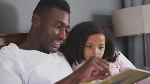 Loving Father Reads Story to Adorable Little Girl