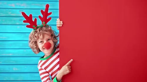 Festive Child with Reindeer Antlers Peeking from Wall