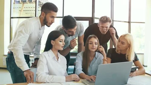 Team Collaborating on Laptop in Modern Office