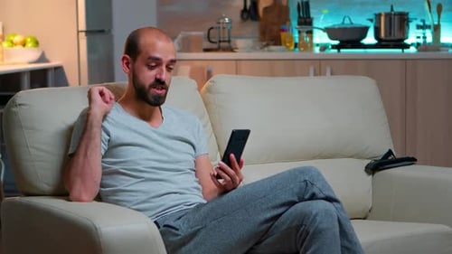 Man Talking on Mobile Phone Video Call at Home