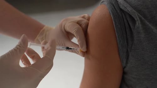 Medical Professional Giving Arm Injection in Clinic