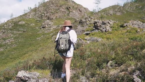 Woman Hikes up Mountain on Sunny Day