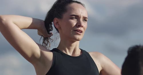 Woman Putting Hair Up in Ponytail Outdoors