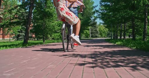 Couple Rides Bicycle Together in Sunny Park