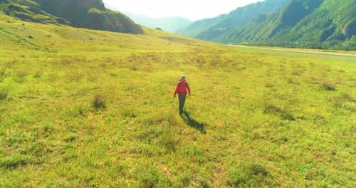 Flight Over Backpack Hiking Tourist Walking Across Green Mountain Field
