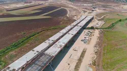 Aerial footage of large highway construction project with tunnels and bridges