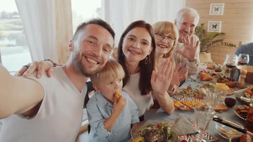 Cheerful Family Smiling and Taking Selfie at Home Holiday Dinner