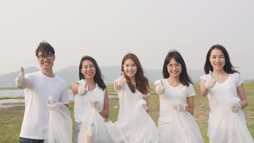 Volunteers Holding Trash Bags Give Thumbs Up