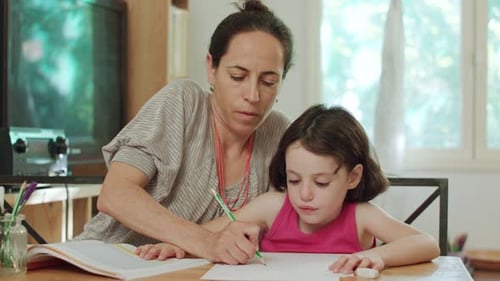 Child Drawing with Help from Adult in Bright Home