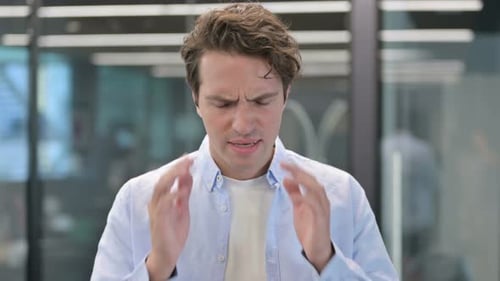 Young Adult Man Experiencing Headache in Office