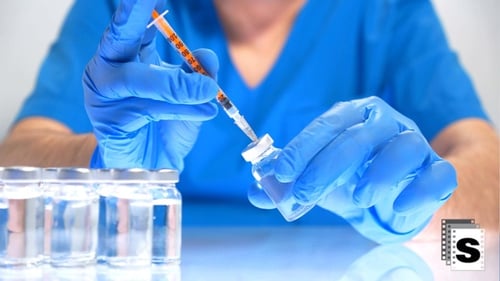 Medical Professional Draws Liquid from Vial with Syringe