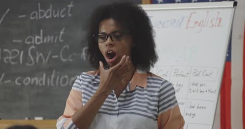 Woman Explains English Grammar in Classroom Setting