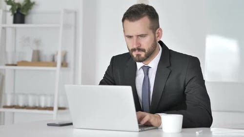 Man in Suit Frustrated Using Laptop
