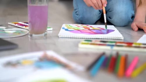 Child Painting Colorful Stripes on the Floor