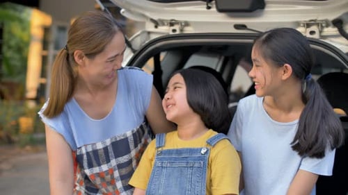 Happy Family Poses Together in Front of Car