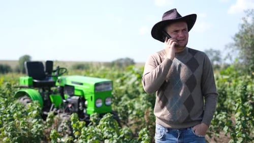 A Farmer in a Field in Colorado USA He is Talking on a Smartphone