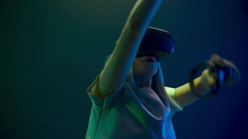 Young Adult Using VR Headset With Hand Controllers