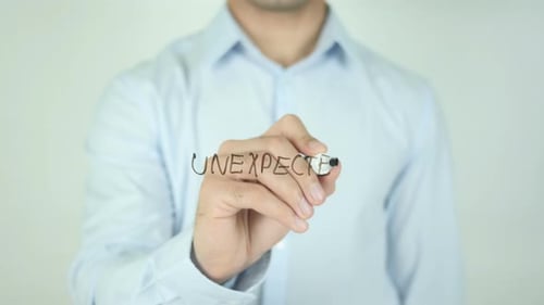 Man Writes the Word Unexpected on Surface