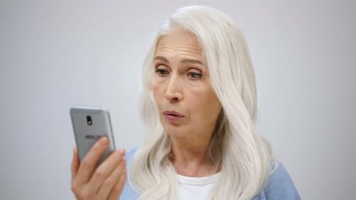 Serious Old Woman Looking Cellphone Indoors