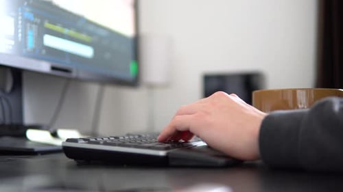 A View of a Person's Hands and a Keyboard As He Works on a Computer and Types on the Keyboard.