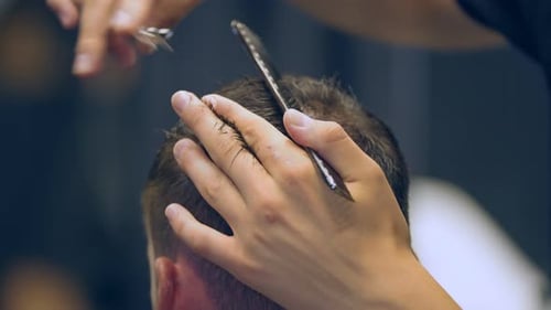 Barber Cuts Man's Hair With Comb and Scissors
