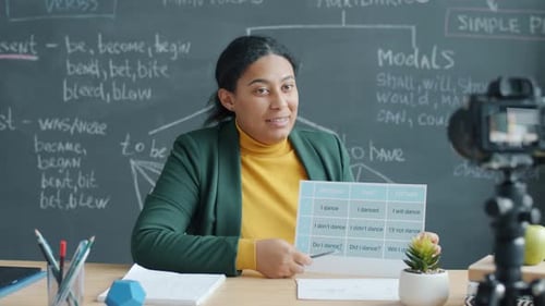 Professeur d'école de langue travaillant sur un cours d'enregistrement en ligne avec caméra vidéo dans un bureau moderne