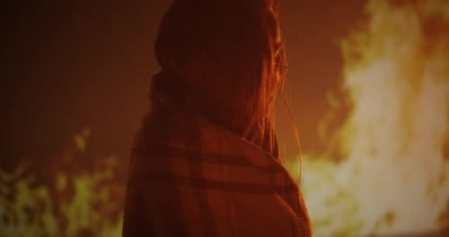 Distressed Woman Crying in Front of Fire