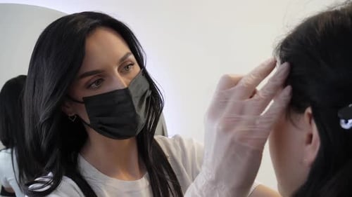 Earlobe Piercing by Technician Wearing Mask