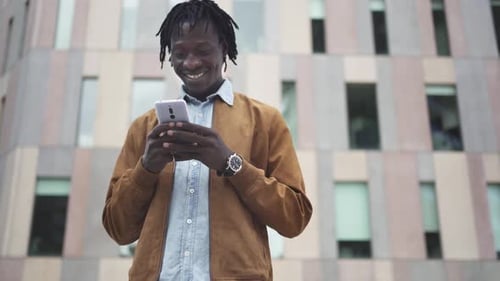 Young Black African Entrepreneur chatting on the phone in a business district