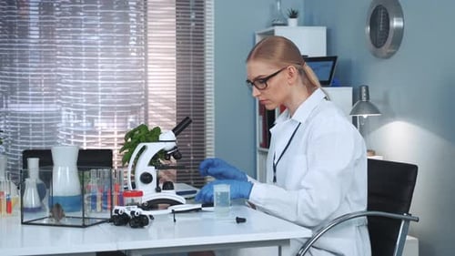 Scientist Using Pipette at Lab Table