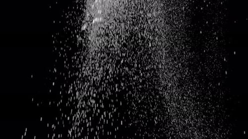 Sparkling White Dust Falling Against Black Background
