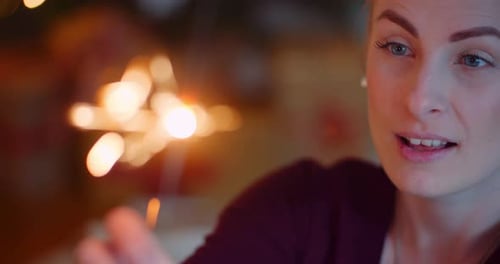 Smiling Young Woman Looking At Sparkler