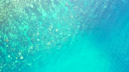 Daytime drone travel shot of a white sandy paradise beach and blue ocean background in colorful 4K