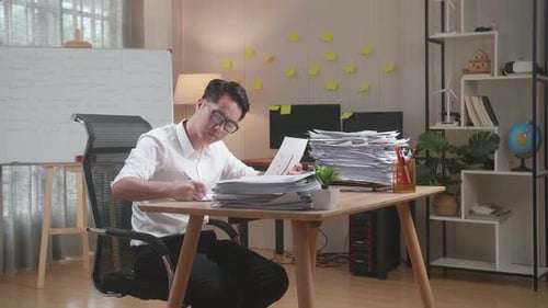 Asian Man Working With Documents At The Office