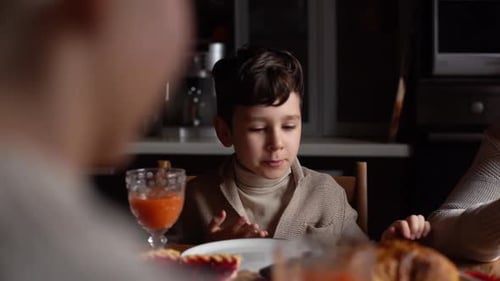 Boy Talking at Dinner Table Inside Home