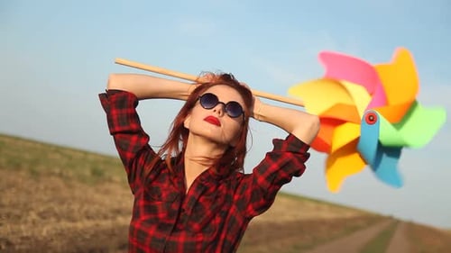 Young Woman Poses with a Pinwheel Outside