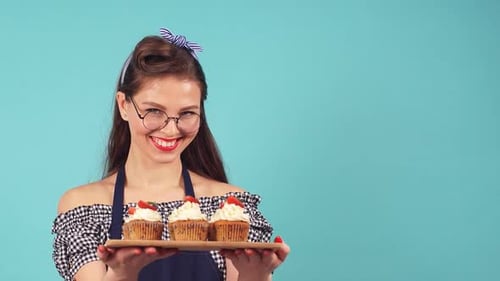 Woman Holding Tray with Cupcakes and Smiling