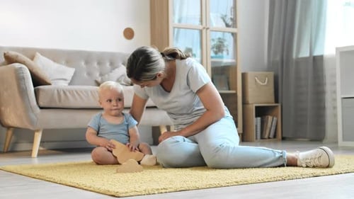 Mother and Infant Play with Wooden Toys at Home