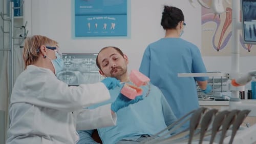 Stomatologist Using Artificial Jaw to Explain Correct Way to Brush Teeth