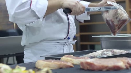 Chef Prepares Meat Portions in Professional Kitchen